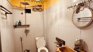 A bathroom with a toilet, shower, and a wooden vanity.