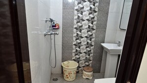 A bathroom with a shower, toilet, sink, and decorative tiles.
