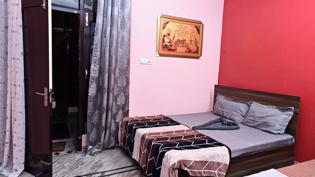 A bedroom with a bed, two bedside tables, a wardrobe, a curtain, and a wall-mounted picture.