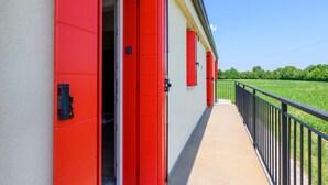 A building with red doors and a balcony overlooking a green field. - GuestHost - Kidane Room 4 Padova (Padua)