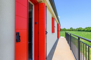 A building with red doors and a balcony overlooking a green field. - GuestHost - Kidane Room 4 Padova (Padua)