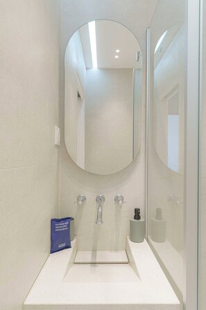 Ein modernes Badezimmer mit großem Spiegel, Waschbecken und Toilette.