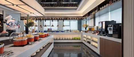 Una cocina moderna con una isla central, distintas estaciones de comida y un bar de café.
