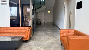 Un vestíbulo moderno con mostrador de recepción, zona de estar y una escalera.