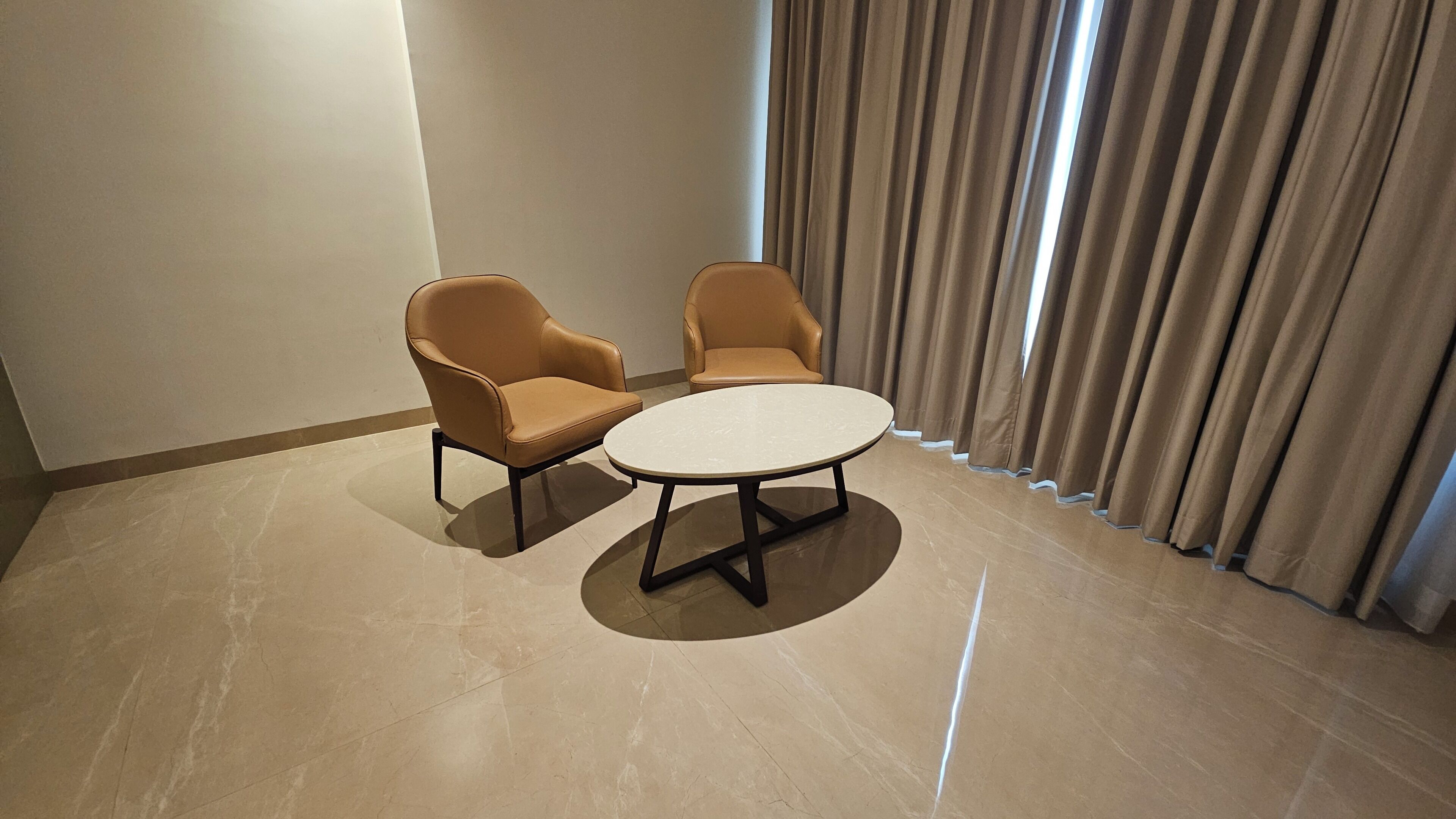 Una habitación con dos sillones de cuero y una mesa redonda.