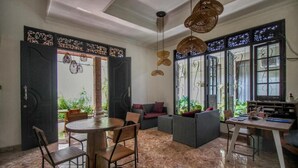 Un espacio habitable de concepto abierto con zona de comedor, asientos y ventanas amplias.