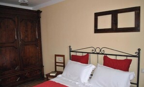 A room with a bed, a wooden wardrobe, and a framed picture on the wall. - "The Infinity" Apartment of Sibillini Montains (Montefortino)