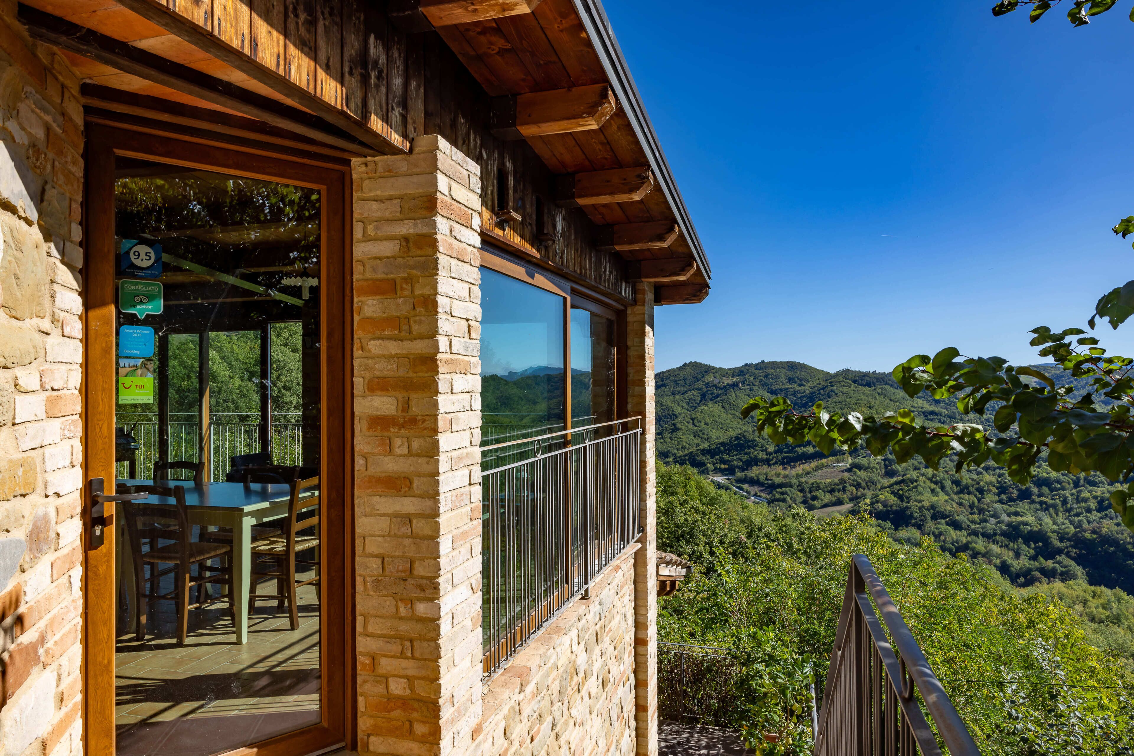 A wooden building with a balcony overlooking a mountainous landscape.