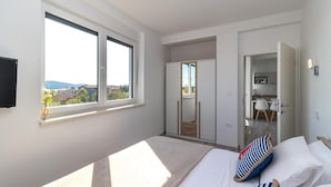 A bedroom with a bed, a window, a wardrobe, and a view of the outside. - Cozy apartment in Medulin with swimming pool (Medulin)