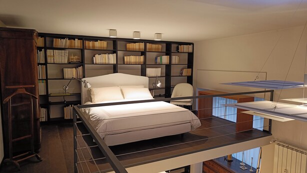 A bedroom with a bed, a desk, and a bookshelf. - Loft, a designer apartment in a prime downtown location (Milano)