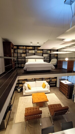 A modern loft-style bedroom with a large bed, a sofa, and a coffee table. - Loft, a designer apartment in a prime downtown location (Milano)