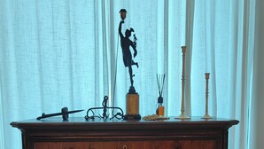 A wooden dresser with drawers, a statue, and decorative items. - Loft, a designer apartment in a prime downtown location (Milano)