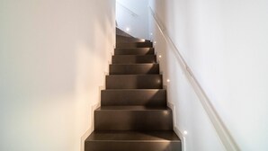 Eine Treppe mit Geländer und einer Wandleuchte.