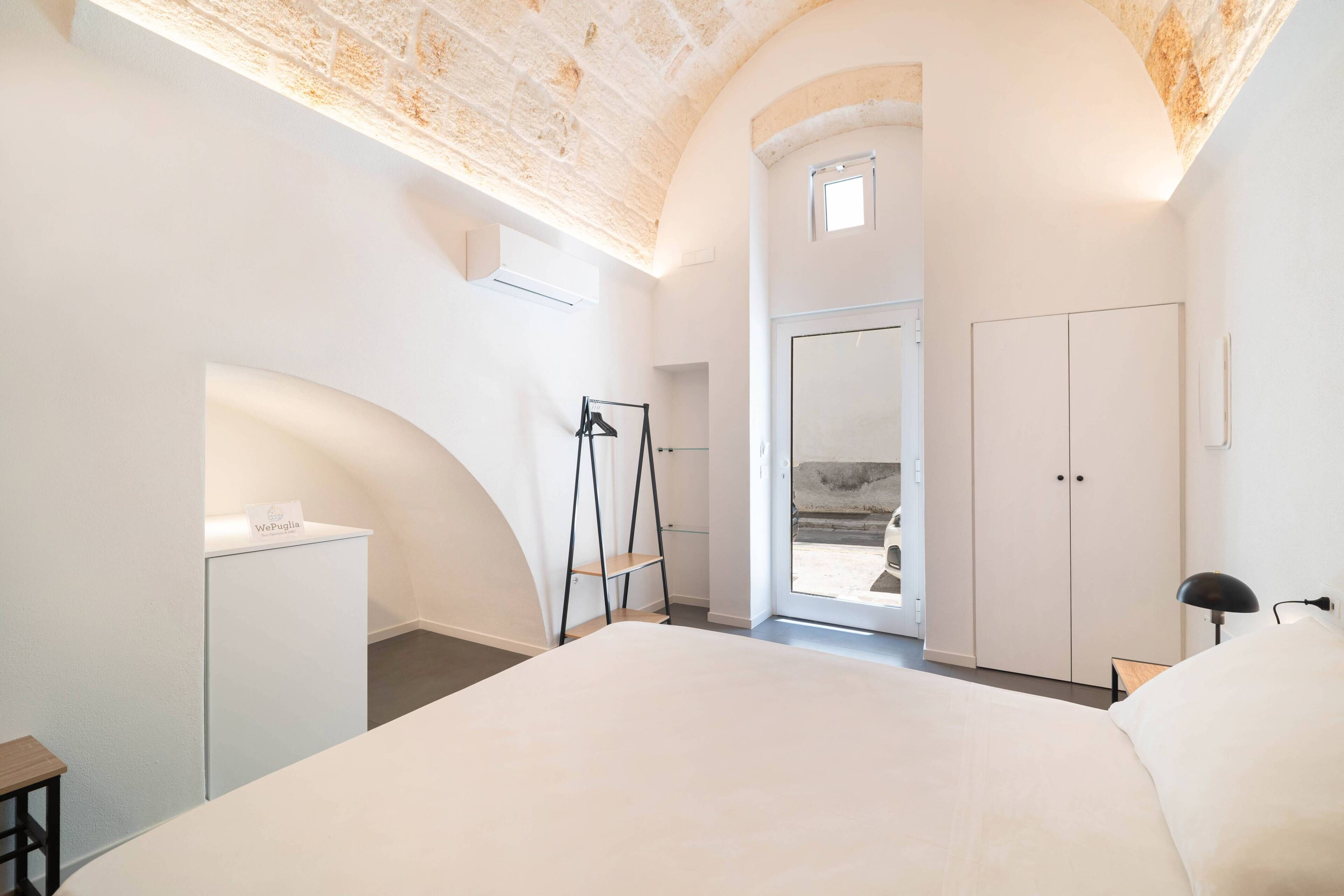 Une chambre avec un grand lit, une armoire, un bureau et une échelle.