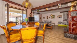 Un salón amplio con mesa de comedor, sillas, sofá y televisor.