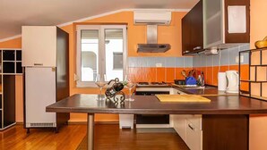 A kitchen with a central island, a built-in oven, and a window. - Cozy apartment in Crikvenica with WiFi (Crikvenica)