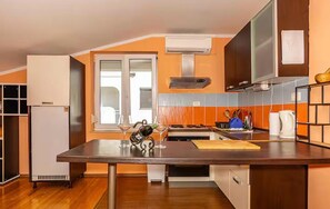 A kitchen with a central island, a built-in oven, and a window.