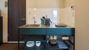 Cocina compacta con lavabo, hervidor y lavavajillas integrado.