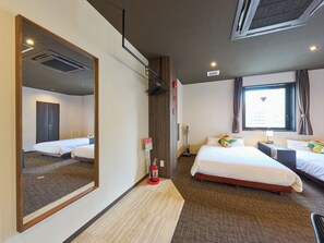 A hotel room with two beds, a large mirror, a fire extinguisher, and a window with curtains.