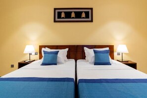 A double bed with white and blue bedding, two bedside lamps, and a framed picture above the bed. - Coastal Villa Mirissa (Mirissa)