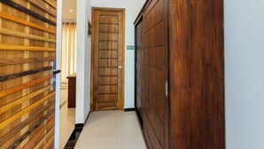 Un pasillo con paneles de madera a la izquierda, una puerta de madera en el centro y un armario de madera a la derecha.