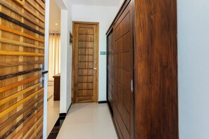 A hallway with wooden paneling on the left, a wooden door in the center, and a wooden wardrobe on the right. - Coastal Villa Mirissa (Mirissa)
