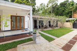 A residential property with a covered patio, a lawn, and a garden area with a potted plant. - Coastal Villa Mirissa (Mirissa)