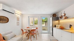 Una cocina moderna con comedor, muebles blancos y un amplio ventanal.