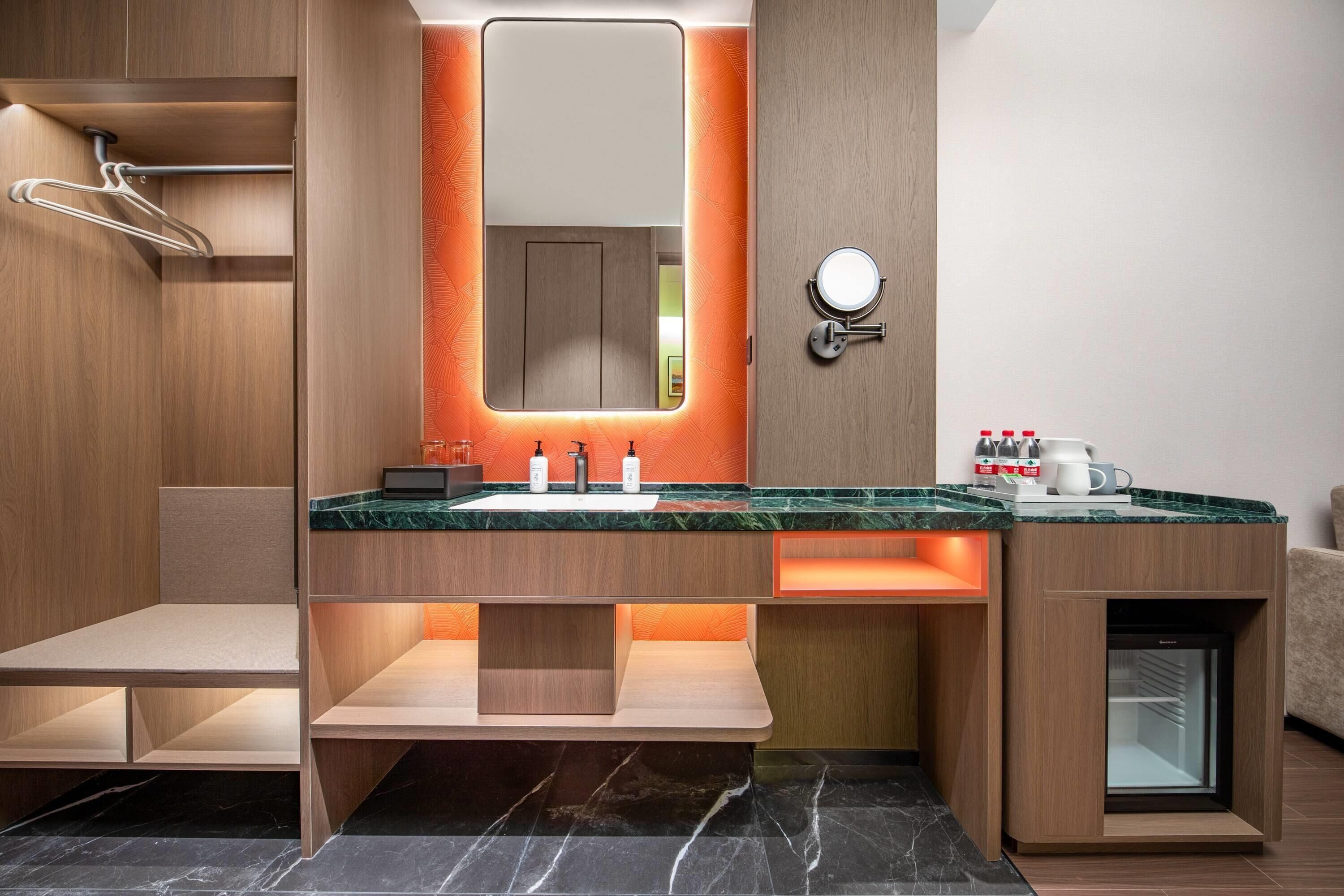 A modern bathroom with a vanity, mirror, and built-in shower.
