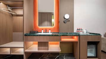 A modern bathroom with a vanity, mirror, and built-in shower.