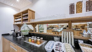 A buffet area with various food items, glassware, and a coffee station. - Hotel Garni Christine - Ischgl (Ischgl)
