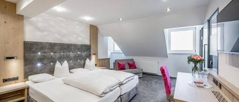 Um quarto moderno com uma cama grande, uma escrivaninha e uma cadeira.