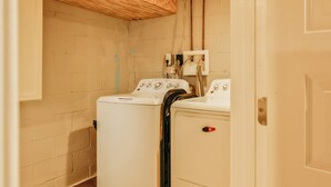 A laundry room with a washing machine and dryer, wooden ceiling, and visible plumbing. - Essex Smart Stay (Essex)