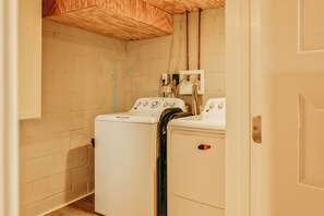 A laundry room with a washing machine and dryer, wooden ceiling, and visible plumbing. - Essex Smart Stay (Essex)
