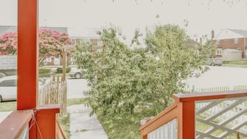 A residential area with a wooden fence, a tree, and a parked car.