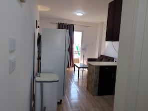 A compact kitchen with a refrigerator, a microwave, and a sink.