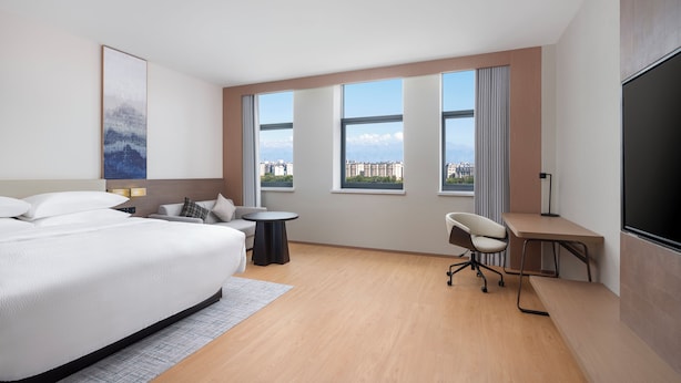 A modern hotel room with a large bed, a desk, a chair, and a TV. - Fairfield by Marriott Urumqi Beijing Road (Urumqi)