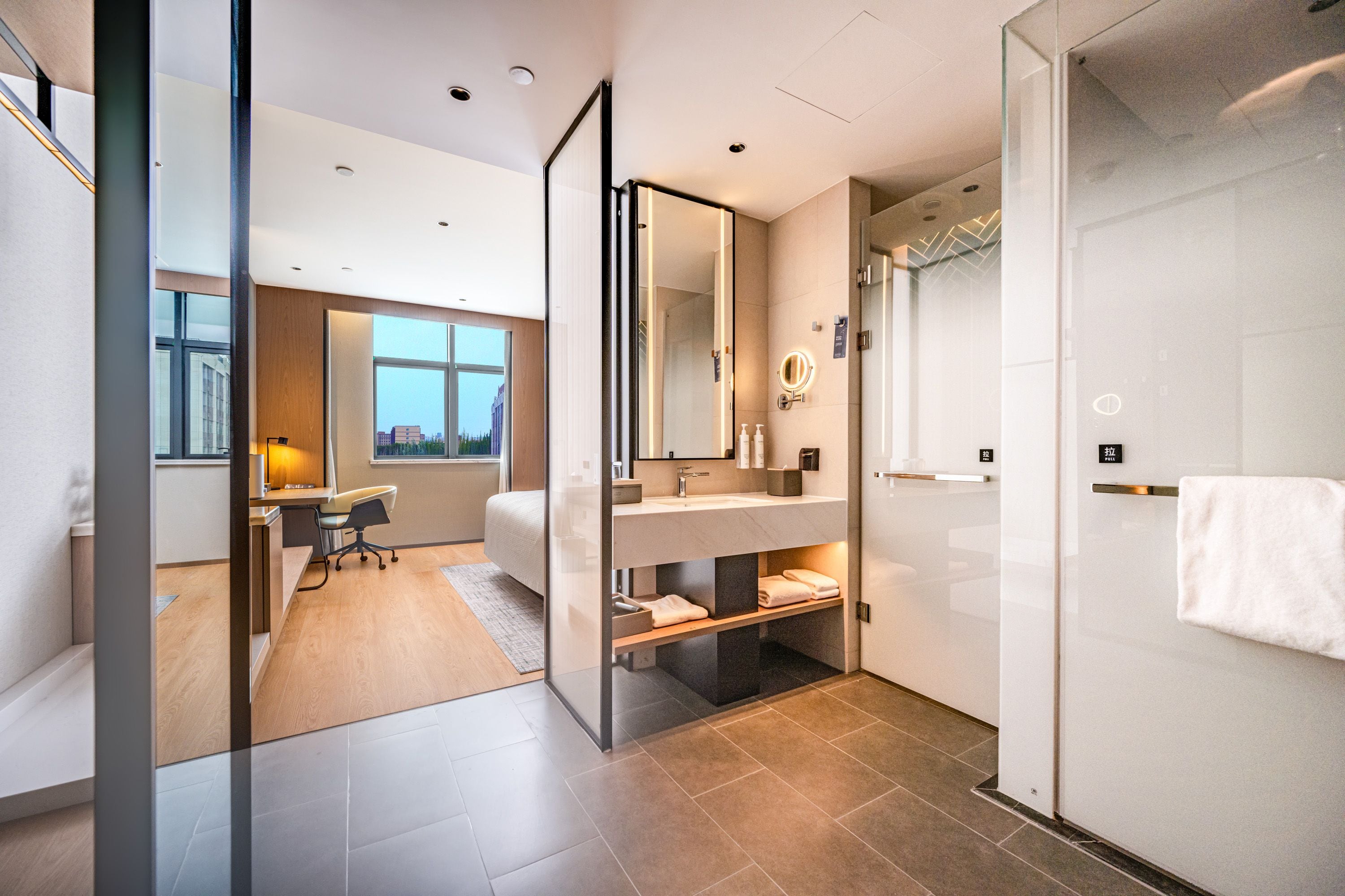 A modern bathroom with a glass shower enclosure, a vanity with a mirror, and a toilet.