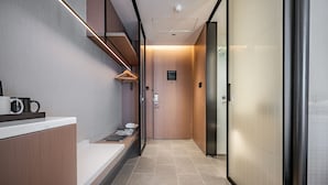 A modern hotel corridor with a reception desk, a coat rack, and a glass elevator door. - Fairfield by Marriott Urumqi Beijing Road (Urumqi)