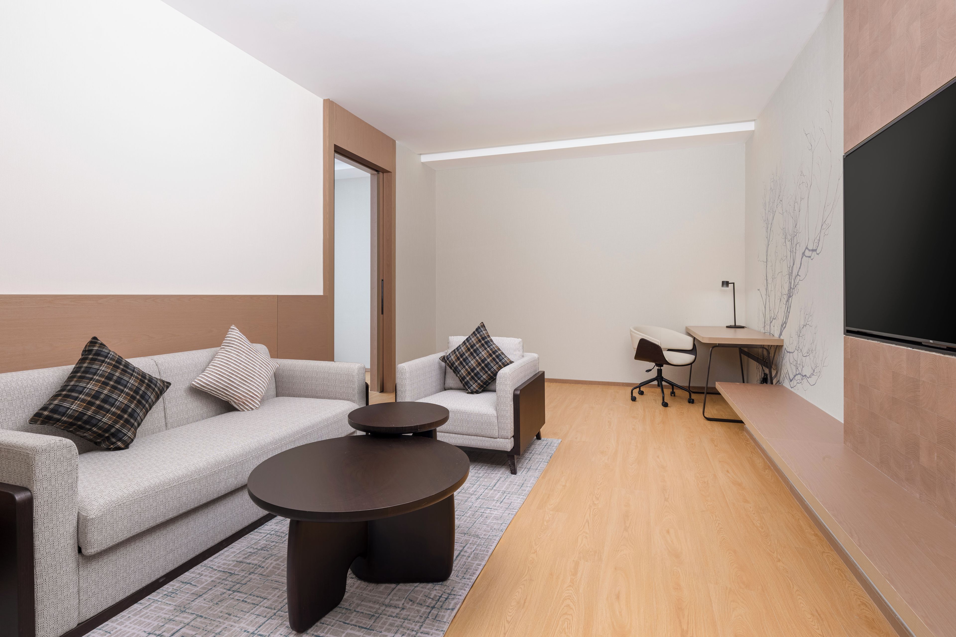 Una sala moderna con un sofá, una mesa de centro y un escritorio con una silla.