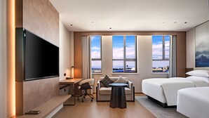 A hotel room with a flat-screen TV, a desk, a chair, a small table, a sofa, and a bed. - Fairfield by Marriott Urumqi Beijing Road (Urumqi)