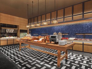 Disposição de buffet com diversos alimentos e uma máquina de café.