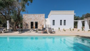 A pool area with a stone building and a white building, both with windows and doors. - Villa in Ostuni with 3 bedrooms sleeps 8 (Ostuni)