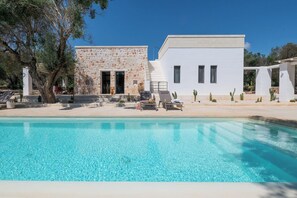 A pool area with a stone building and a white building, both with windows and doors. - Villa in Ostuni with 3 bedrooms sleeps 8 (Ostuni)