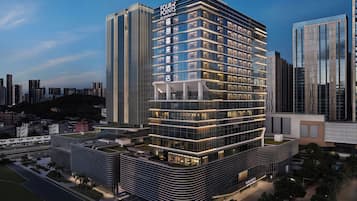 Een modern hotel met een hoekligging, met een opvallend 'Four Points by Sheraton' bord, meerdere verdiepingen en een glazen gevel.
