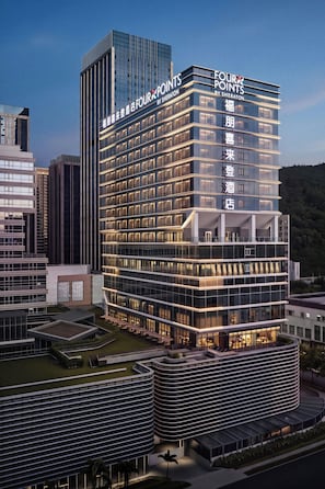 Un hotel de varios pisos con una señalización destacada que indica 'FOUR POINTS BY SHERATON'.
