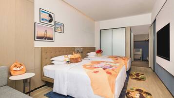 Una habitación de hotel con cama, sofá, una mesita y televisor.