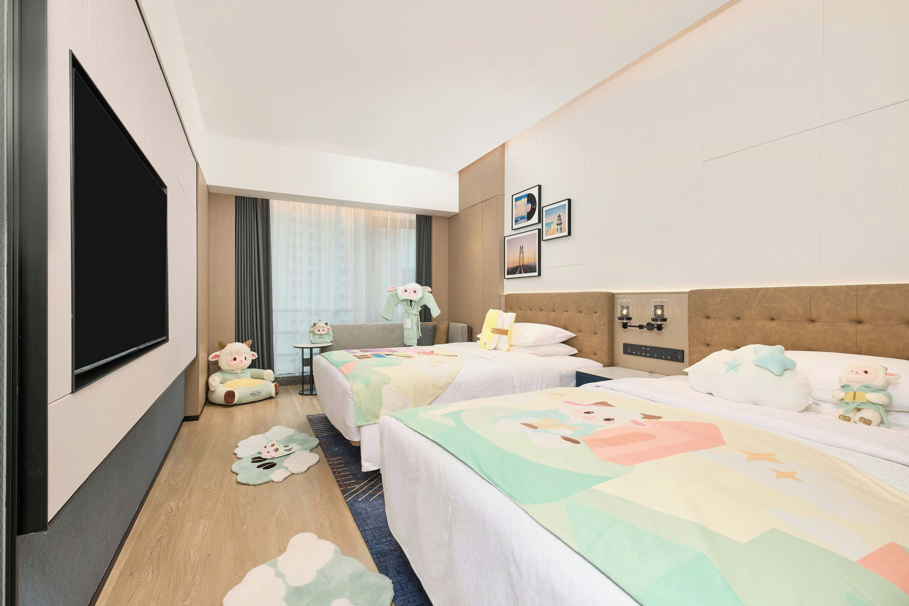 Habitación de hotel con dos camas, televisión, una mesita y ventana con cortinas.