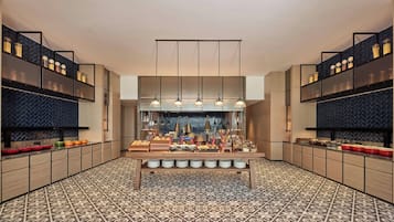 Une cuisine moderne dotée d’un îlot central, de luminaires suspendus et d’un revêtement de sol à motifs.