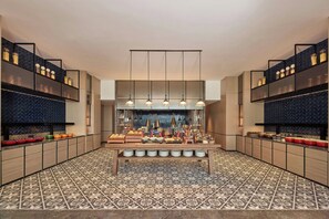 Une cuisine moderne dotée d’un îlot central, de luminaires suspendus et d’un revêtement de sol à motifs.